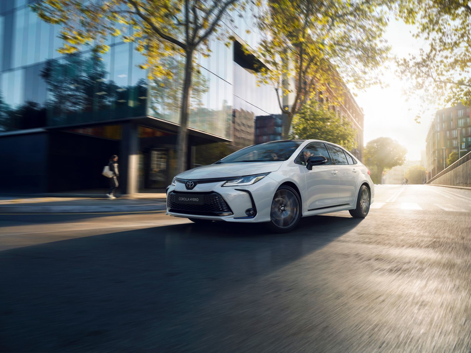 Toyota Corolla sedaan sõidab päiksepaistelisel päeval linnas