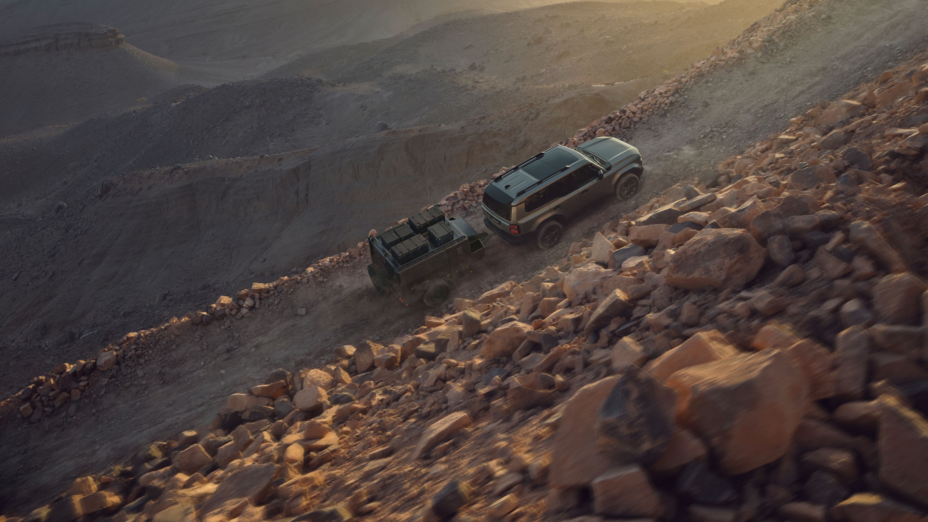 Land Cruiser towing a trailer up a remote desert track