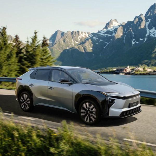 Toyota bZ4X fährt auf einer Landstrasse und im Hintergrund sind die Berge zu sehen